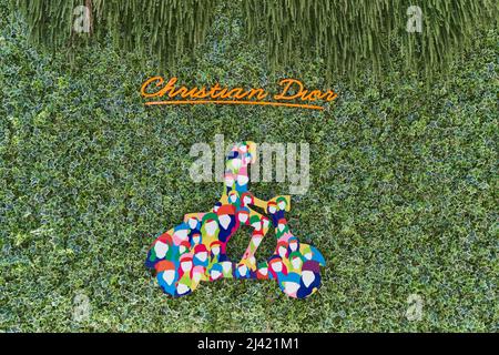 TIVAT, MONTENEGRO - JULY 15, 2021: Christian Dior brand sign on a wall overgrown with ivy Stock Photo