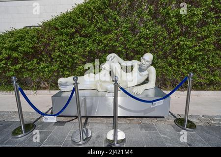 TIVAT, MONTENEGRO - JULY 15, 2021: Sculpture of a lying man with big legs in Porto Montenegro, modern art Stock Photo