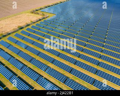 Many photovoltaic panels of a solar farm as competition to agriculture in Germany Stock Photo