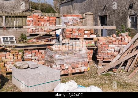 Pallets of reclaimed bricks sit at a building site. Stock Photo