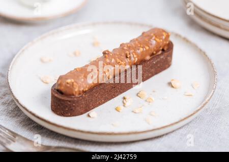Chocolate cake bar with hazelnut crumbs decorated on light background. Stock Photo