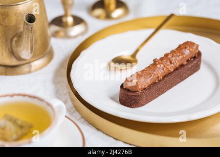 Chocolate cake bar with hazelnut crumbs decorated on light background. Stock Photo