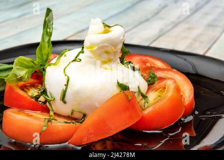 Burrata is a fresh cow's milk cheese, made of pasta filata and round in shape, with an external appearance similar to that of mozzarella in the shape Stock Photo