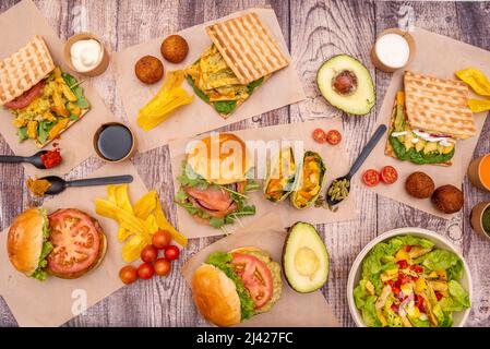 Healthy fast food dishes with assorted vegetable, fish and chicken burgers, tapas croquettes and salads with fruits and vegetables Stock Photo