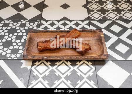 Two wonderful strips of fried torrezno Soria style on a wooden tray Stock Photo