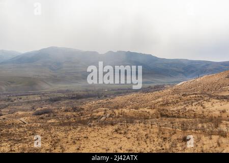 Sarykum dune. Dagestan, Russia. A unique sandy mountain in the Caucasus on a cloudy day. Grass grows on a sand dune. Stock Photo