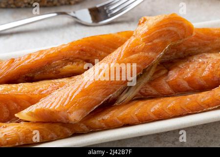 Fresh smoked salmon bellies on a plate close up Stock Photo
