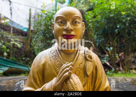 Beautiful unique buddha statue close shot, looking at the camera. Golden religious sculpture representing a buddhist/monk. Ten Thousand Buddhas Stock Photo