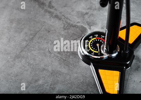 Air pump with a manometer and a wheel inflation hose on a dark background with free space Stock Photo