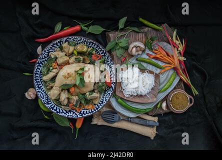 Green curry with Chicken and Green-white varieties of Thai eggplants (Kaeng khiao wan) in Ceramic bowl served with Thai rice noodles (Fermented rice f Stock Photo