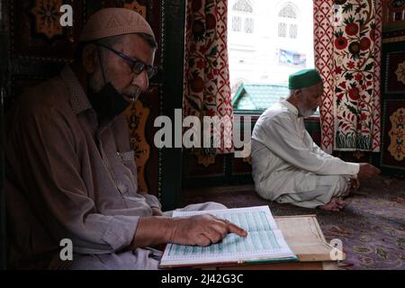 A man recites the Holy Quran inside the Masjid or Mosque during a cold ...