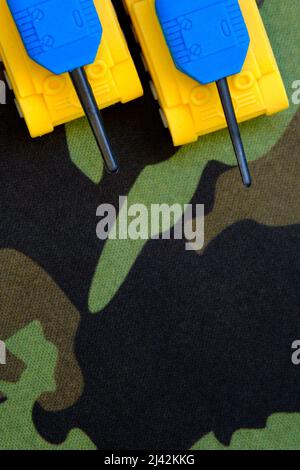 Yellow-blue flag of ukraine on the background of camouflage fabric, background or screensaver, selective focus Stock Photo
