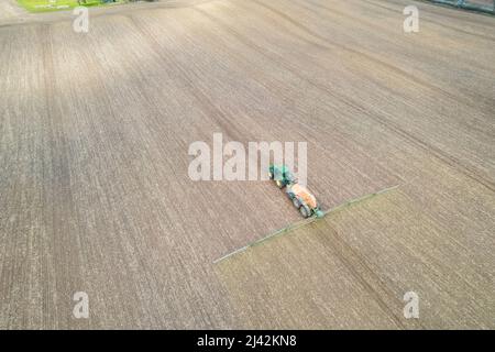 a tractor spraying fertilizer on a field Stock Photo