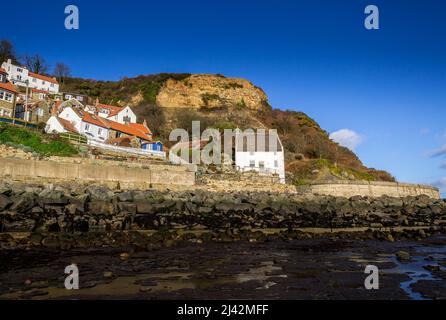 Cottages by the sea in Runswick Bay, North Yorkshire sit protected behind the sea defences Stock Photo