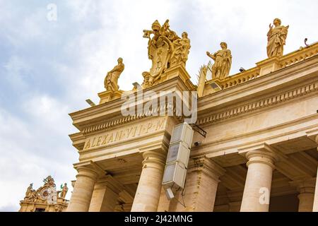 The colossal Doric colonnades, four columns deep with magnificent sculptures frame the trapezoidal entrance to the St. Peter's Basilica,Vatican Stock Photo