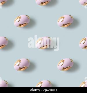 Happy Easter violet eggs decorated golden potal on blue background. Seamless pattern. Stock Photo