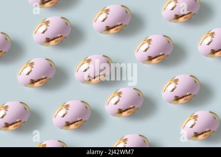 Happy Easter violet eggs decorated golden potal on blue background. Seamless pattern. Stock Photo