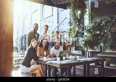 We prefer our meetings in a relaxed setting. Portrait of a group of colleagues having a meeting at a cafe. Stock Photo