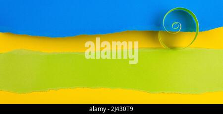 Pattern. Ripped paper edge with copy space, green, blue and yellow color background. Flat lay. Copy space. Stock Photo