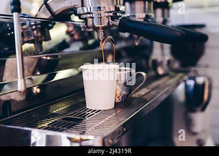 Close-up of espresso pouring from coffee machine. Concept coffee in cafe Stock Photo