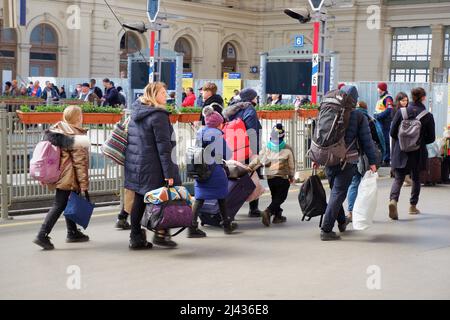 Ukrainian refugee family hurry to the train with luggage at the East Railway Station Stock Photo