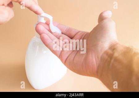 Liquid soap bottle and pressing on the dispenser, soap on the palm. Washing hands Stock Photo