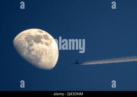 Mnichovo Hradiste, Czech Republic. 11th Apr, 2022. A plane AIRBUS A350 (Nr SIA8187) of Singapore Airlines from Berlin in Germany to Singapure flies past the waning moon in the blue sky over the Czech Republic. (Credit Image: © Slavek Ruta/ZUMA Press Wire) Stock Photo