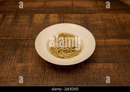 A simple and tasty first course - Recipe Second course: Spaghetti with botarga, Bronte pistachio and lemon zest Stock Photo