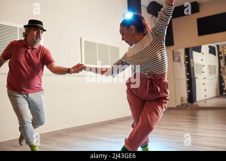 A man and a woman dancing Lindy Hop in a dance studio Stock Photo
