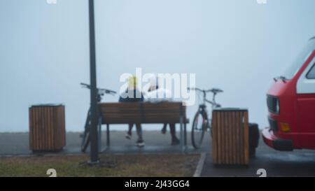 Two girls sit on a bench in the park and drink coffee from a car cafe. Blur. High quality photo Stock Photo