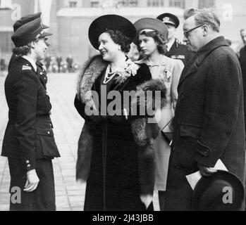 The Queen Attends National Review of Fire Women at London Region Headquarters in Lambeth - The Queen accompanied by Princess Elizabeth and Mr. Herbert Morrison, Secretary of State Speaking to one of the firewomen officers. The Queen accompanied by Princess Elizabeth to-day inspected Women C.D. workers, police, NFS, wardens, ambulance and first-aid workers, fire guards and members of the W.V.S. at County hall to-day. She told them 'No Victory but for your help' and added 'That is a thought which gives me pride as a woman, it also given me something more valuable then pride, that is hope.' Dece Stock Photo