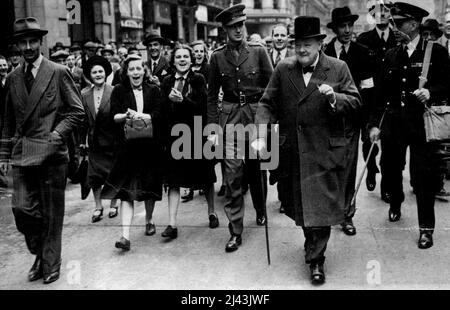 The Premier Inspects -- Girls in the crowded followed Mr. Churchill to give him a cheer. Huge crowds followed Mr. Winston Churchill today when he inspected the damage and bomb craters caused by last night's raids. Mr. Churchill asked the crowded if they were downhearted and cries of 'no' were heard from them all. September 10, 1940. (Photo by Fox Photos). Stock Photo