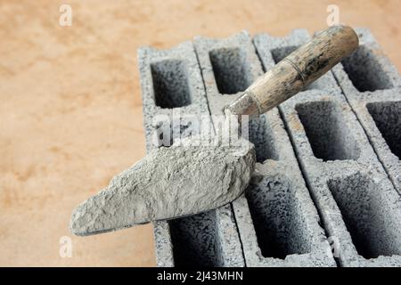 Cement powder or mortar with  trowel put on the Concrete brick for construction work. Stock Photo