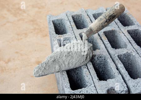 Cement powder or mortar with  trowel put on the Concrete brick for construction work. Stock Photo