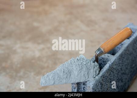 Cement powder or mortar with  trowel put on the Concrete brick for construction work. Stock Photo