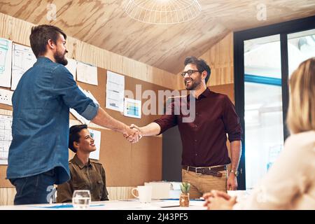 I look forward to making this business thrive together. Shot of businesspeople shaking hands during a meeting in an office. Stock Photo