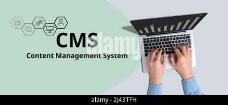 Acronym CMS or Content Management System. The person works at the laptop Stock Photo