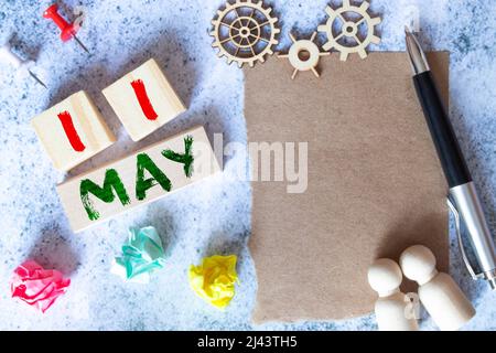 wooden calendar with date 11 May and easel on blue background, place for text. Stock Photo