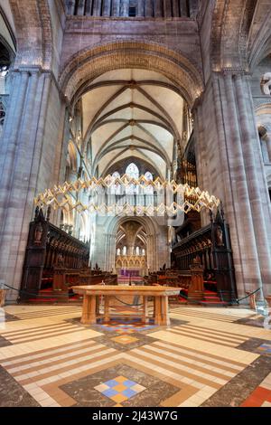 Low angle view of majestic,colorful,ornate windows,decorative golden symbols and lighting,hanging from high ceiling and arches of the cathedral church Stock Photo