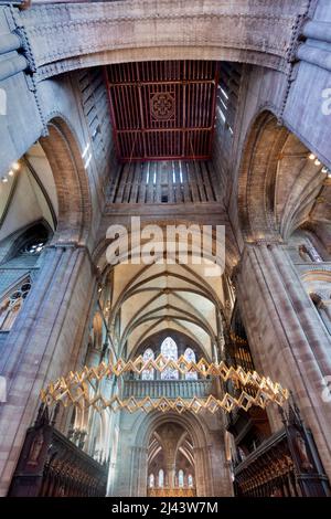 Low angle view of majestic,colorful,ornate windows,decorative golden symbols and lighting,hanging from high ceiling and arches of the cathedral church Stock Photo