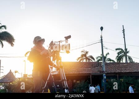 Unrecognizable cameraman films a live TV show in a park outdoors Stock Photo