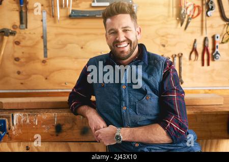Whatever it is, Im sure I can build it. Portrait of a handsome young handyman standing in his workshop. Stock Photo