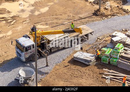 Kemerovo, Russia - 24 june 2021. Delivery of materials to the construction site on a truck equipped with a crane, selective focus Stock Photo