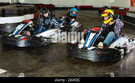 Group of people driving go-carts at racing track Stock Photo