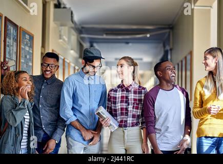 Catching up after class. Cropped shot of a group of young university students walking through the campus halls. Stock Photo