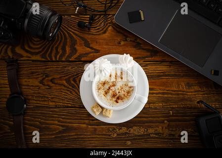 Work from home. desk office with laptop and camera, coffee cup on wood table. Flat lay top view Stock Photo