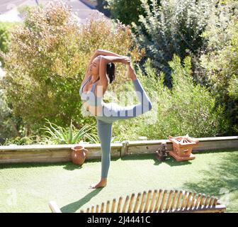 I live for yoga. Shot of a beautiful young woman doing yoga outside on a sunny day. Stock Photo