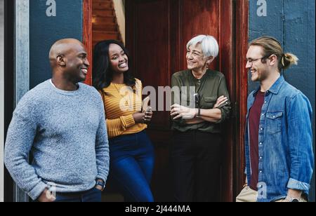 These chats always inspire us to do better. Shot of a group of businesspeople having a discussion together while standing outside their office Stock Photo