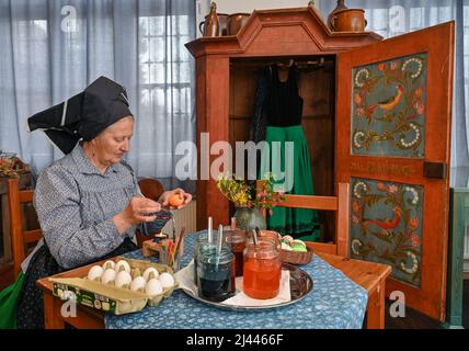 Dissen, Germany. 05th Apr, 2022. Babette Zenker, director of the Lower Sorbian Museum of Local History in Dissen, wears a Sorbian-Wendish working costume and decorates Easter eggs using the wax batik technique. (to dpa With quill and wax: Easter egg painting in Sorbian) Credit: Patrick Pleul/dpa/17�Թ����� Live News Stock Photo