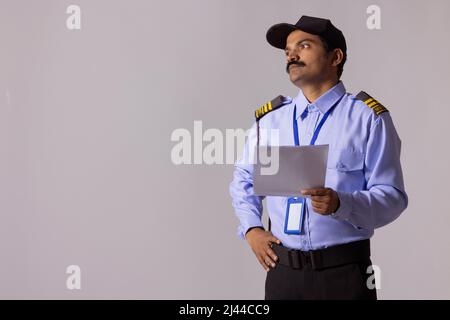 Security guard looking away with holding papers in hand Stock Photo